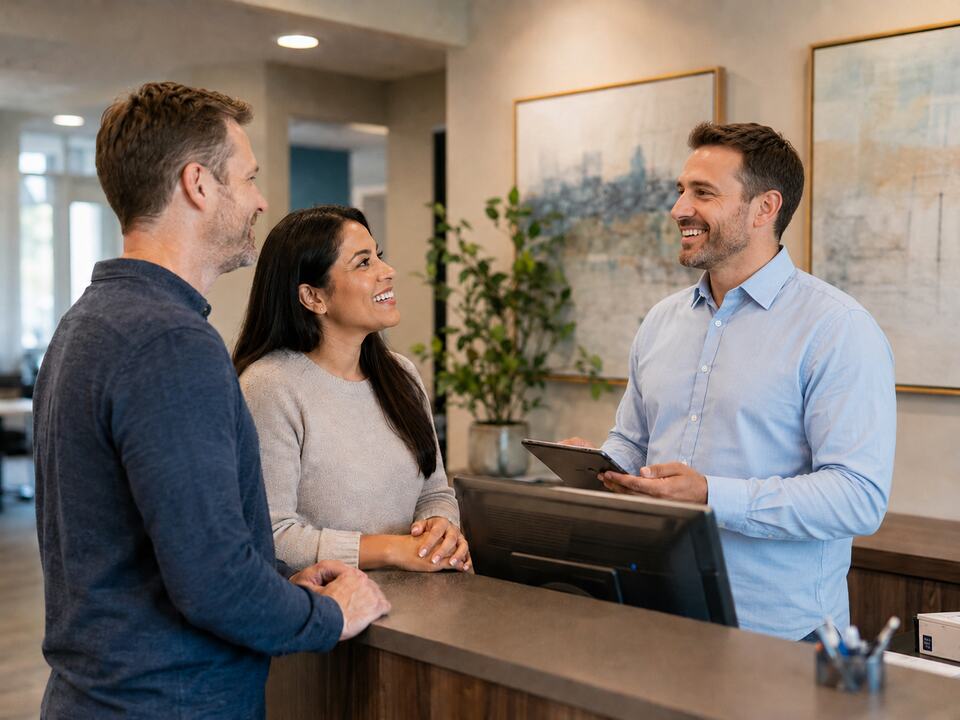 White staff member welcoming visitors at a warm front desk